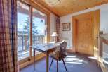 This charming property boasts a cozy study area with a rustic wooden desk and chair, perfect for work or relaxation.
