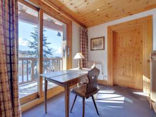 This charming property boasts a cozy study area with a rustic wooden desk and chair, perfect for work or relaxation.