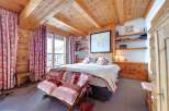 Step into a cozy bedroom retreat, featuring a warm wooden ceiling and walls that create a rustic ambiance.