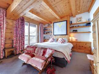 Step into a cozy bedroom retreat, featuring a warm wooden ceiling and walls that create a rustic ambiance.