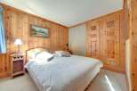 This cozy bedroom features beautiful wood paneling throughout, creating a warm and inviting atmosphere.