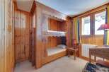 This charming bedroom features custom-built bunk beds crafted from warm, inviting wood, perfect for a cozy retreat.