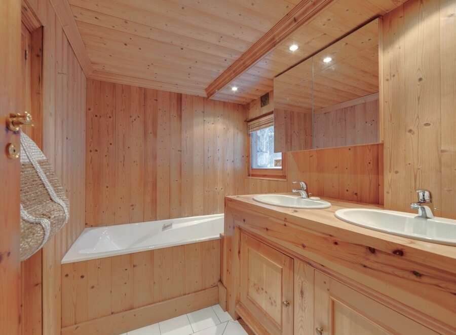 This stunning bathroom showcases a warm, inviting ambiance with its all-wood paneling.