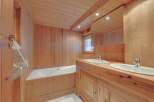 This stunning bathroom showcases a warm, inviting ambiance with its all-wood paneling.