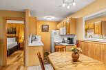 Step into this charming kitchen, featuring warm wood cabinetry and a cozy dining area.