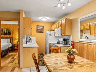 Step into this charming kitchen, featuring warm wood cabinetry and a cozy dining area.
