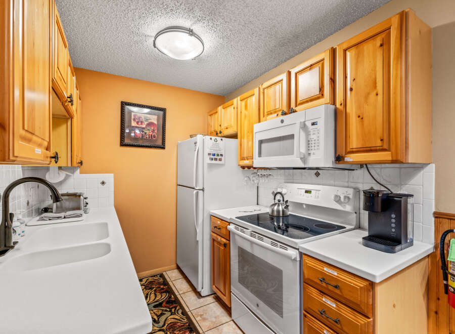 This charming kitchen boasts warm wooden cabinetry and a bright, inviting atmosphere.