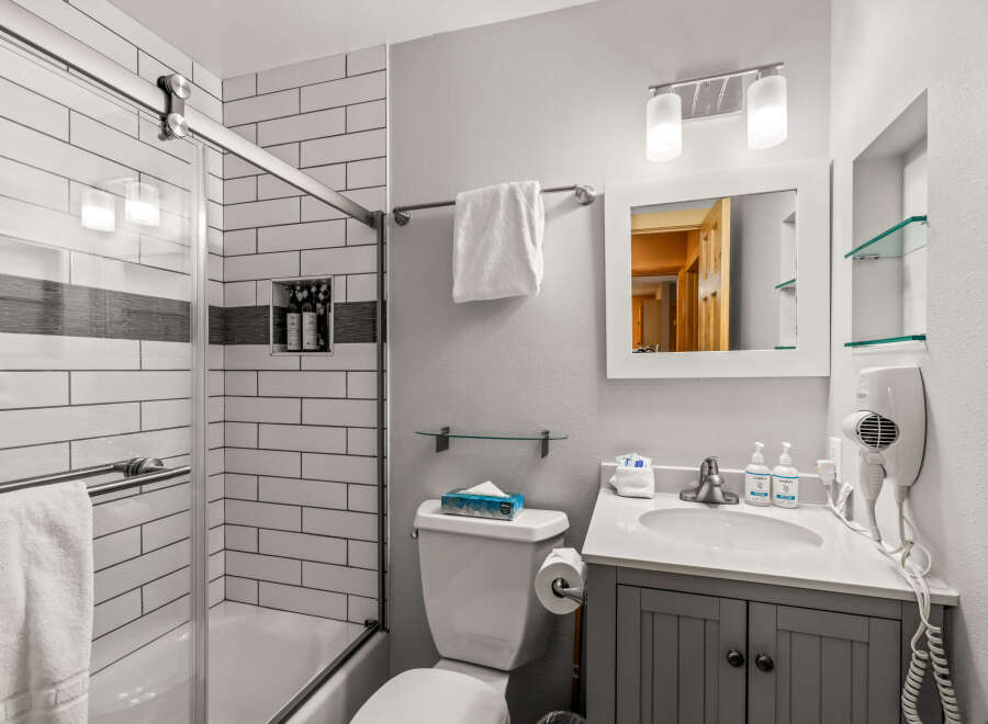 Step into this beautifully designed bathroom, featuring a modern shower with a glass door and stylish subway tile.