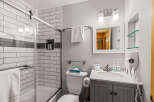 Step into this beautifully designed bathroom, featuring a modern shower with a glass door and stylish subway tile.