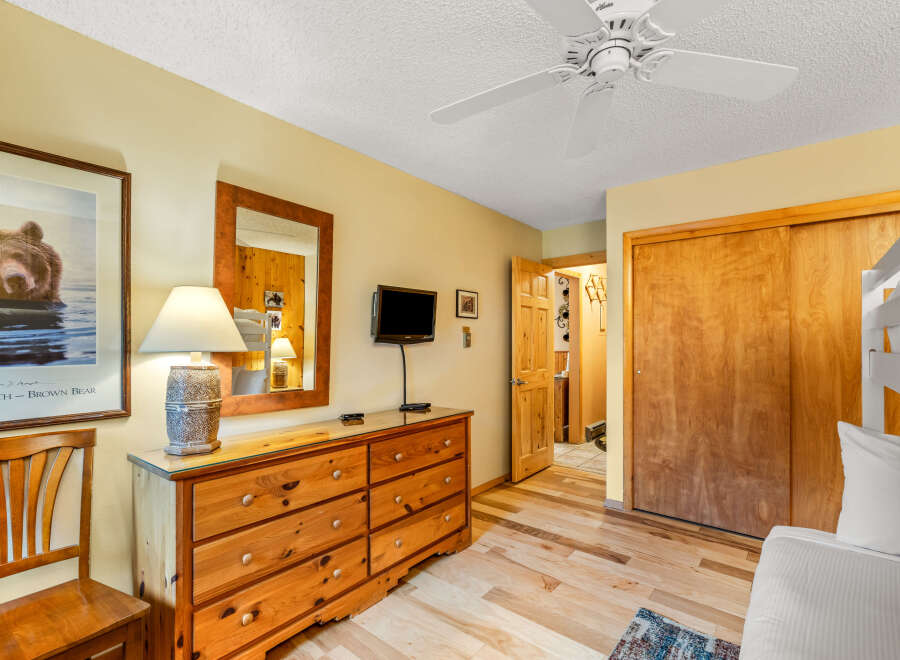 This cozy bedroom features a rustic wooden dresser with ample storage, perfect for organizing belongings.