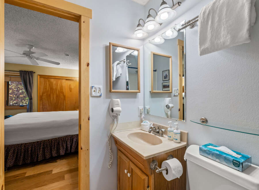 This charming bathroom features a well-lit vanity area with a mirror, perfect for your morning routine.
