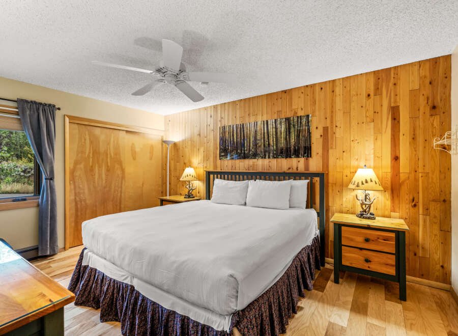 This cozy bedroom features a rustic wood-paneled wall that adds warmth and character.