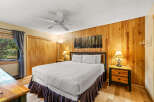 This cozy bedroom features a rustic wood-paneled wall that adds warmth and character.