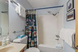 This charming bathroom features a cozy ambiance with its light blue walls and a unique shower curtain.
