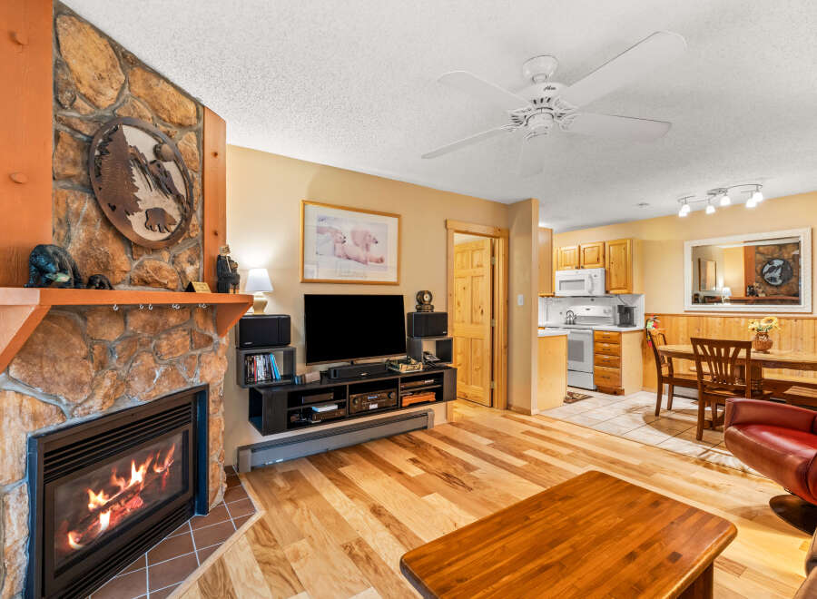 This cozy living space features a stunning stone fireplace, perfect for those chilly evenings.