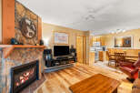 This cozy living space features a stunning stone fireplace, perfect for those chilly evenings.