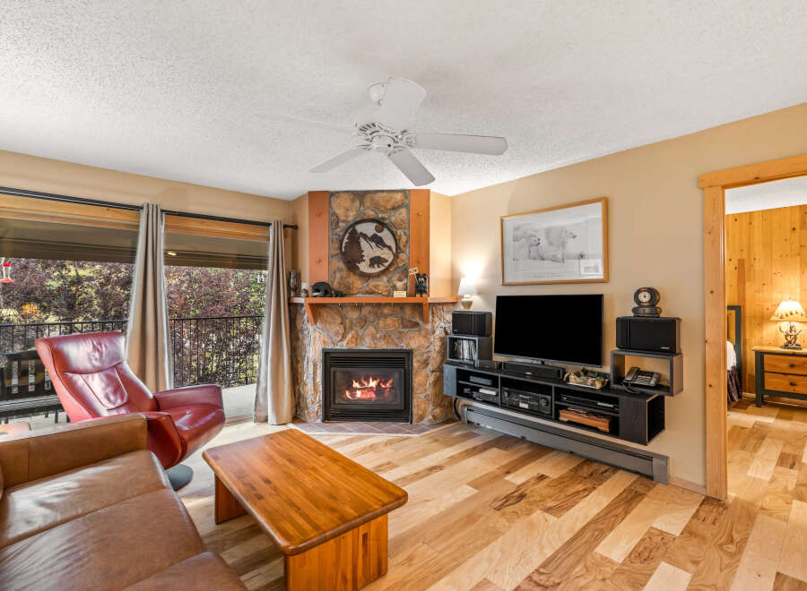 This cozy living room features a stunning stone fireplace, perfect for those chilly evenings.