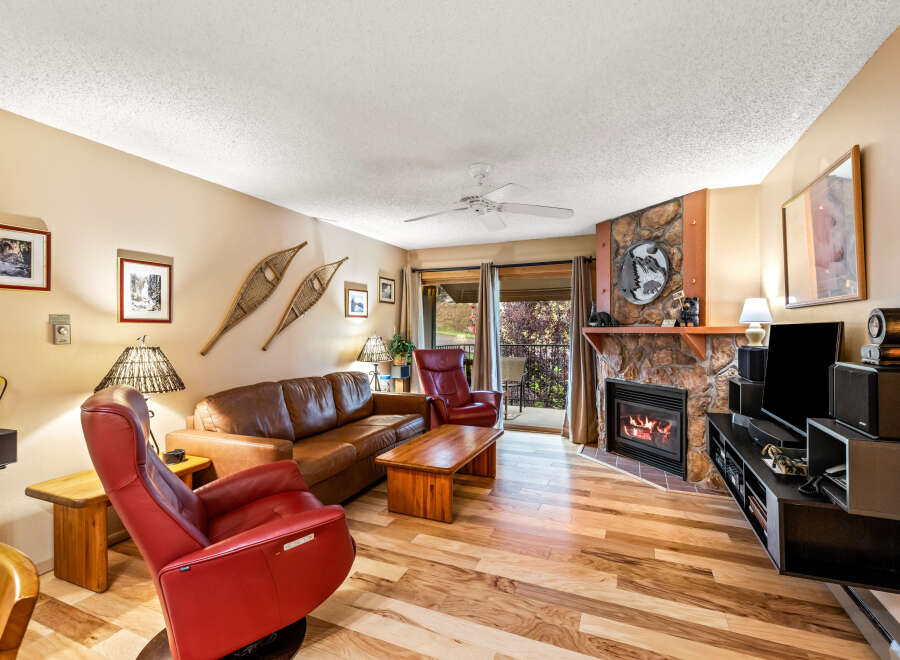 This cozy living room features a stunning stone fireplace, perfect for those chilly evenings.