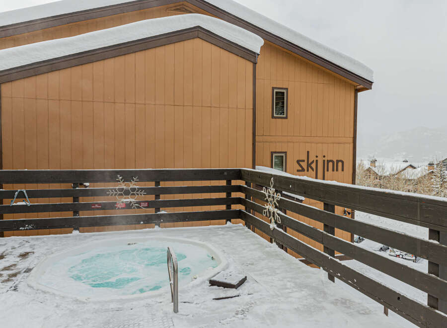 Enjoy a relaxing soak in the hot tub with stunning views of the snow-covered mountains.