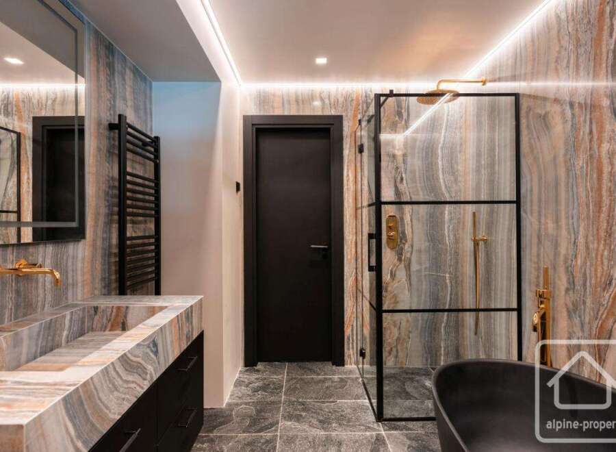 Experience luxury in this stunning bathroom featuring a sleek black door and a modern glass shower enclosure.