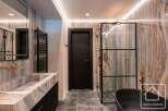 Experience luxury in this stunning bathroom featuring a sleek black door and a modern glass shower enclosure.