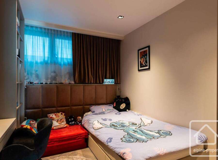 This cozy bedroom features a comfortable bed with a unique Stitch-themed duvet cover, perfect for a relaxing night's sleep.