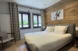 This cozy bedroom features a comfortable bed with crisp white linens, perfect for a relaxing stay.