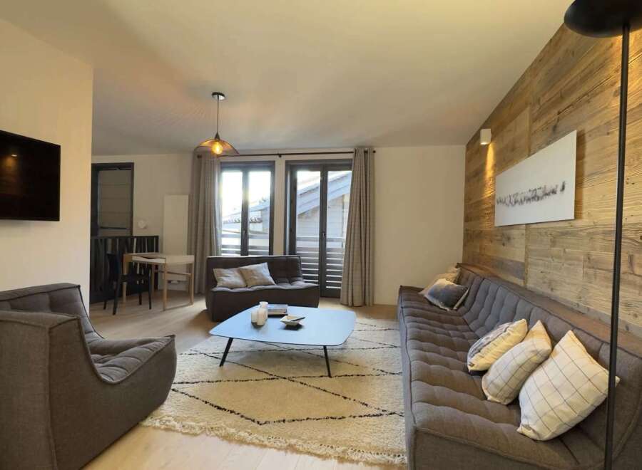 Experience modern living in this stylish property, featuring a cozy living room with a comfortable sofa and armchairs.