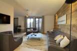 Experience modern living in this stylish property, featuring a cozy living room with a comfortable sofa and armchairs.