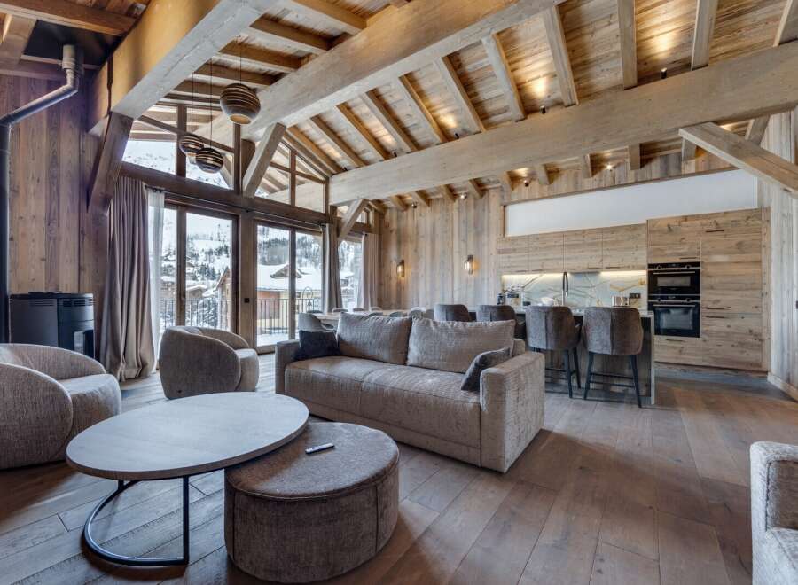Experience luxury living in this stunning chalet, featuring a spacious open-plan design with exposed wooden beams and a cozy fireplace.