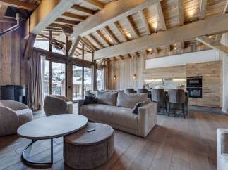 Experience luxury living in this stunning chalet, featuring a spacious open-plan design with exposed wooden beams and a cozy fireplace.
