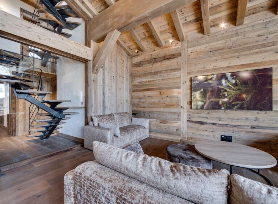 Experience rustic elegance in this stunning property, featuring exquisite wooden paneling and a modern staircase.