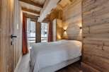 Experience the warmth of this cozy bedroom, featuring stunning wooden walls and ceilings that create a rustic ambiance.