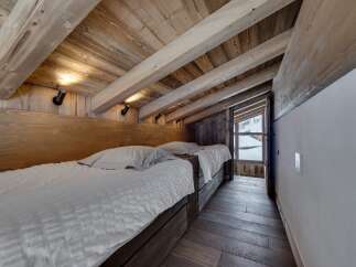 This cozy bedroom features a rustic wooden ceiling and walls, creating a warm and inviting atmosphere.