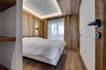 This cozy bedroom features a stunning wooden ceiling and walls, creating a warm and inviting atmosphere.