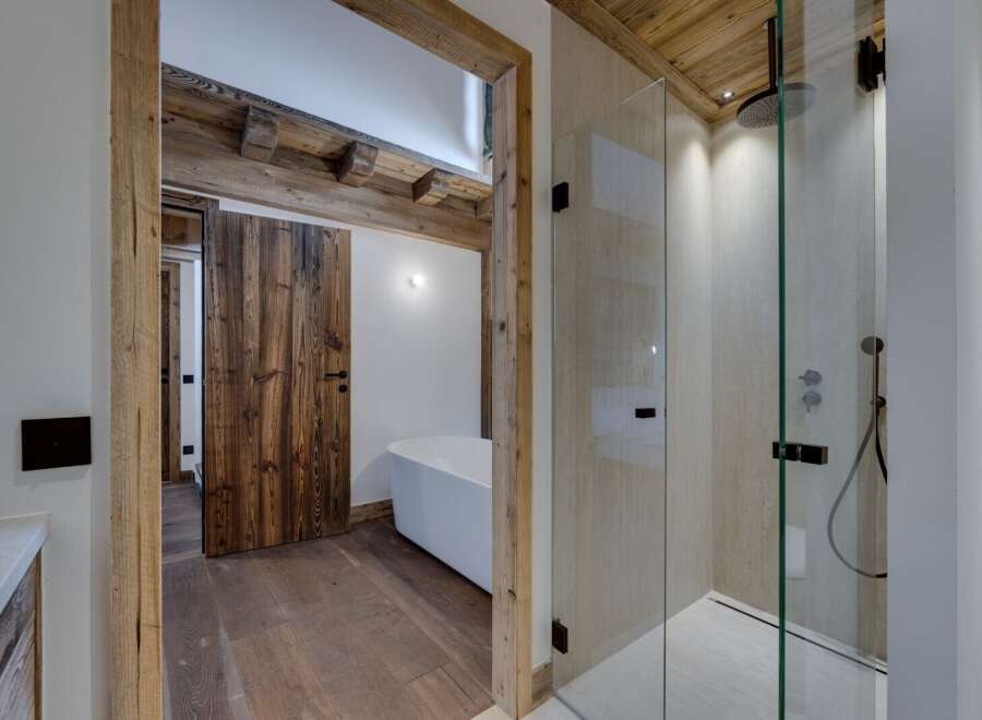 This luxurious bathroom features a stunning combination of rustic and modern design elements.