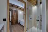 This luxurious bathroom features a stunning combination of rustic and modern design elements.