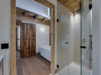 This luxurious bathroom features a stunning combination of rustic and modern design elements.