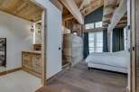 Experience rustic elegance in this stunning property, featuring a master bedroom with a unique wooden ceiling and walls.