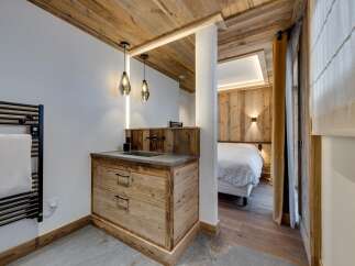 Experience rustic elegance in this stunning property, featuring a beautifully designed bathroom with a wooden vanity and modern fixtures.