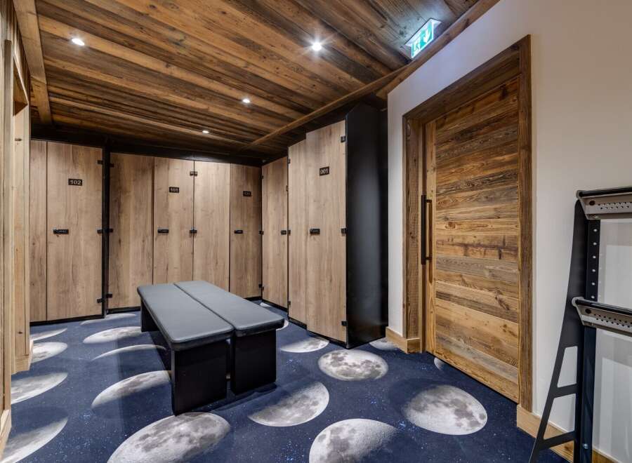 Step into luxury with this stunning locker room, featuring custom wooden lockers and a unique moon-themed carpet.