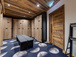 Step into luxury with this stunning locker room, featuring custom wooden lockers and a unique moon-themed carpet.