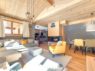 Experience the warmth of this stunning living space, featuring a cozy fireplace and a stylish yellow armchair.