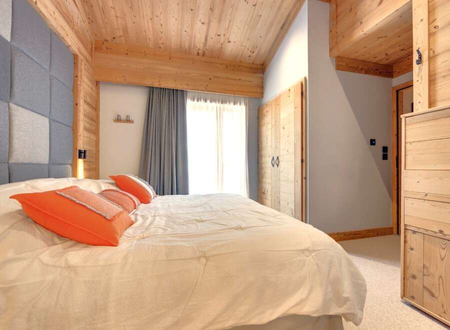 This cozy bedroom features a stunning wooden ceiling and accents, creating a warm and inviting atmosphere.