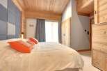 This cozy bedroom features a stunning wooden ceiling and accents, creating a warm and inviting atmosphere.