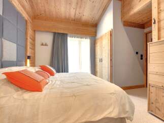 This cozy bedroom features a stunning wooden ceiling and accents, creating a warm and inviting atmosphere.