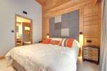 This cozy bedroom features a stunning wooden accent wall and ceiling, creating a warm and inviting atmosphere.