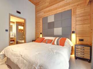 This cozy bedroom features a stunning wooden accent wall and ceiling, creating a warm and inviting atmosphere.