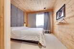 This cozy bedroom features a stunning wooden ceiling and walls, creating a warm and inviting atmosphere.