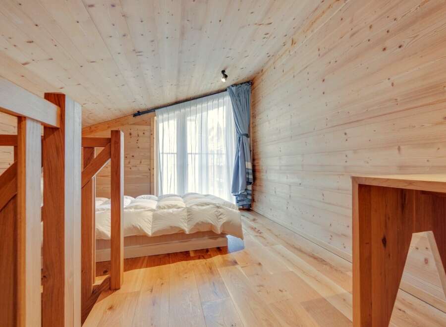 This cozy bedroom features a warm wooden interior, creating a serene and inviting atmosphere.